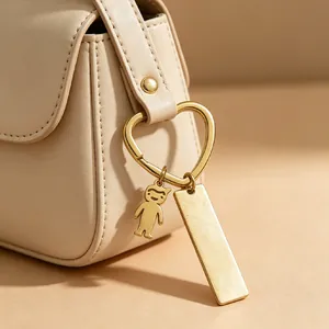 Gros plan du porte-clés en cœur doré en acier inoxydable avec pendentif garçon et barre