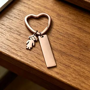 Vue détaillée du porte-clés en forme de cœur or rose avec charm fille et étiquette vierge