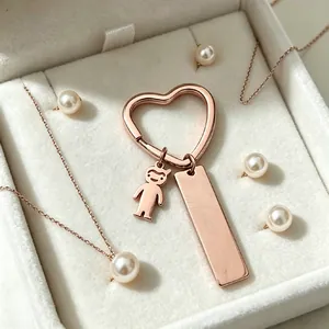 Porte-clés cœur or rose personnalisé avec barre gravable et breloque garçon vue
