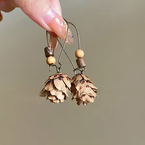 Detailed view of retro ethnic style earrings featuring pinecone pendants and wooden beads