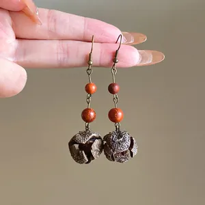 Close-up detail of retro ethnic style pinecone dangle earrings with wooden beads