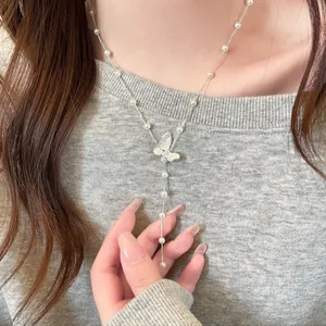 Detailansicht einer Perlenkette mit einem gefalteten Schmetterlingsanhänger am Modell
