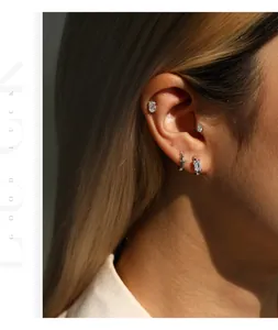 Vue détaillée de clous d'oreilles en argent S925 et moissanite sur une oreille modèle