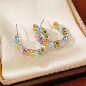 Detailed view of colorful oval zircon hoop earrings placed in a luxury jewelry box