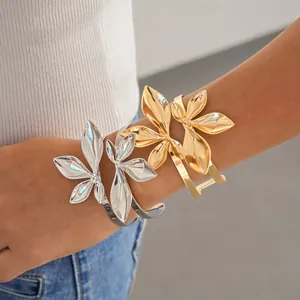 Detailansicht von gold- und silberfarbenen zweilagigen Blatt-Manschettenarmbändern