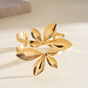 Detaillierte Makroansicht eines goldenen Metallarmreifs mit aufwendigen zweilagigen Blattmotiven