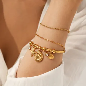 Close-up of 18K gold plated stainless steel bracelet set with ocean themed charms