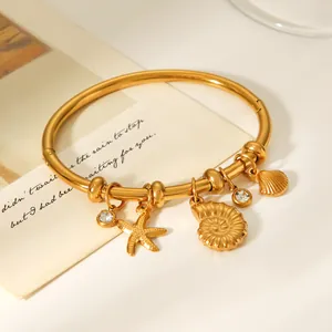 Close-up of 18K gold plated stainless steel bangle with nautical sea charms