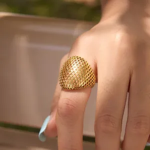 Gros plan détaillé d'une bague dôme en maille creuse dorée minimaliste pour femme