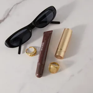 Gros plan de bagues en maille dorée sur marbre avec accessoires cosmétiques