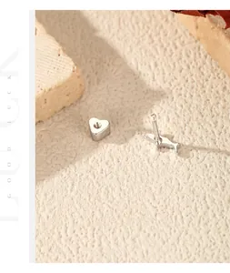 Dettaglio degli orecchini per cartilagine in argento 925 a vite con cuore e delfino