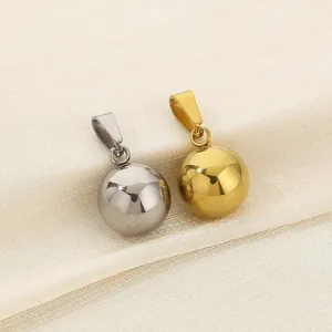 Detailed view of polished gold and silver mirror-finish sphere pendants on silk.