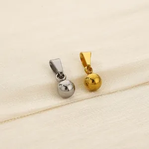 Close-up of gold and silver mirror polished ball pendants in titanium steel