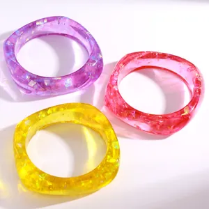 Detailansicht bunter, klobiger Harzarmreifen mit Glitzerfolie in Violett, Rosa und Gelb