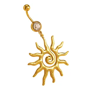 Primo piano di un piercing all'ombelico a sole in acciaio dorato con spirale