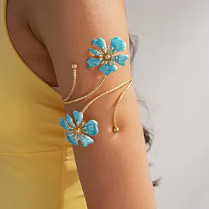 Dettaglio di un bracciale da braccio dorato con eleganti fiori in smalto blu