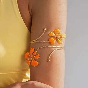 Vista di un elegante bracciale a fiori in smalto dorato sulla parte superiore del braccio