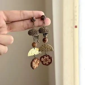 Detailed view of ethnic style acorn beaded earrings featuring wooden and brass textures.
