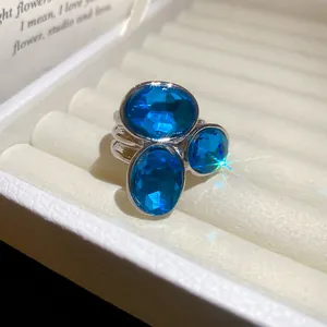 Detailed view of elegant silver adjustable ring with three stunning oval blue gems