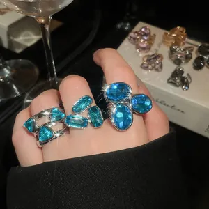 Detailed view of sparkling blue oval and rectangular crystal rings in vintage silver finish
