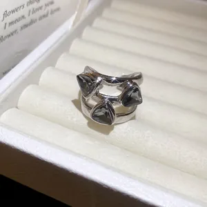 Detailed view of a vintage-style open ring with three triangular dark grey crystals.