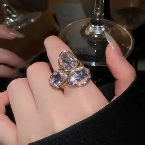 Macro view of a sparkling rose gold fashion ring featuring a cluster of three oval pink stones