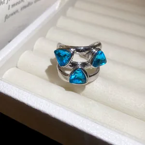 Silver-toned adjustable ring featuring three triangular-cut blue gemstones