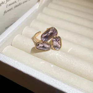 Close-up of vintage gold ring with three rectangular purple crystals in a gift box