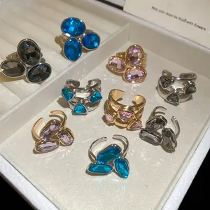 Detailed view of colorful oval crystal open rings arranged in a luxury jewelry display box