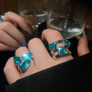 Detailed shot of luxury adjustable rings featuring vibrant blue faceted gemstones on silver bands