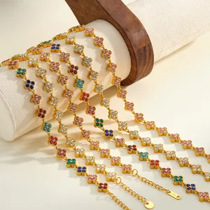 Primo piano di braccialetti in acciaio inossidabile dorato con motivi a fiori colorati.