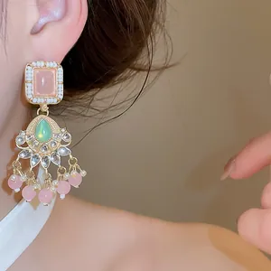 Nahaufnahme von eleganten Vintage-Kronleuchter-Ohrringen mit rosa Steinen und Perlen
