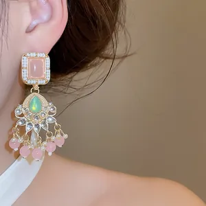 Detaillierte Nahaufnahme der Vintage-Hofstil-Ohrhänger mit rosa und grünen Steinen
