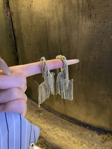 Exaggerated silver fringe tassel stud earrings with unique geometric twisted design detail.