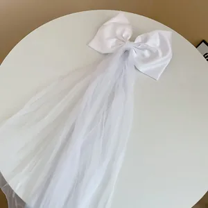Vue détaillée du nœud en satin blanc élégant avec un long voile en maille fluide.