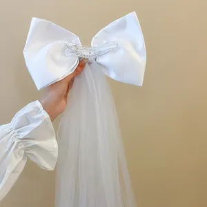 Gros plan d'une pince à cheveux nœud blanc avec d'élégants glands en tulle