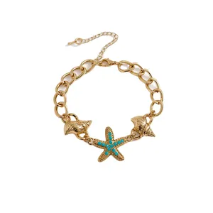 Bellissimo bracciale a catena dorata con ciondoli a forma di stella marina e conchiglia.