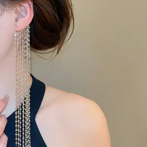 Gros plan d'un élégant long earcuff à pampilles de perles dorées multicouches