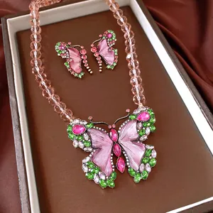 Close-up of a vintage butterfly necklace and earrings set with pink and green crystals