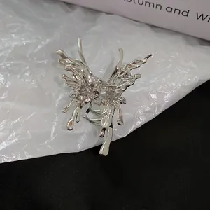 Close-up of a silver liquid metal butterfly hair claw with a polished wrinkled texture