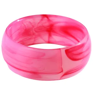 Detail eines rosa Marmor-Resin-Armreifs mit unregelmäßigen geometrischen Wirbeln auf Weiß