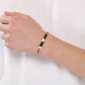 Primo piano di un bracciale a catena cubana in acciaio al titanio dorato con piastra curva