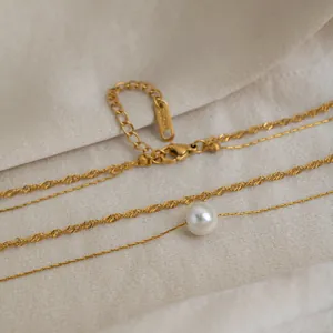 Vue détaillée montrant la texture délicate d'un collier en or à double couche avec perle