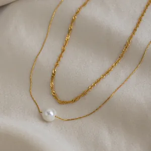 Détail du collier double rang plaqué or 18 carats avec pendentif perle blanche.