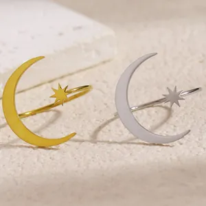 Close-up of stainless steel star and moon open rings in gold and silver
