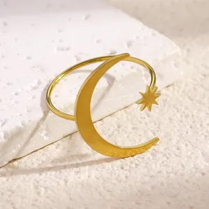 Close-up of a gold stainless steel open ring with crescent moon and star design