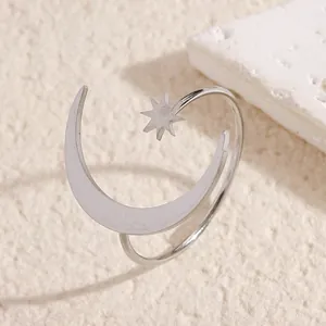 Close-up detail of minimalist stainless steel star and moon adjustable open ring