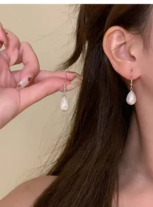 Primo piano di eleganti orecchini vintage a goccia con perle francesi