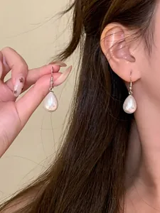 Dettaglio ravvicinato di orecchini con perle a goccia per un look vintage francese elegante
