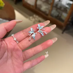 Élégantes boucles d'oreilles fleurs bleu clair avec cristaux et détail bague argentée